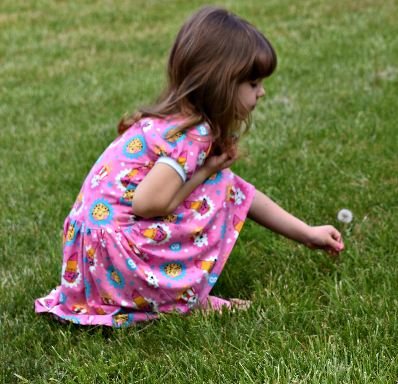 Amelie raglan dress, pdf sewing pattern by Frocks & Frolics. Raglan puff sleeves and ribbed neckband. Low gathered waist. Dress in Jersey with kiddo pink print and white trim.