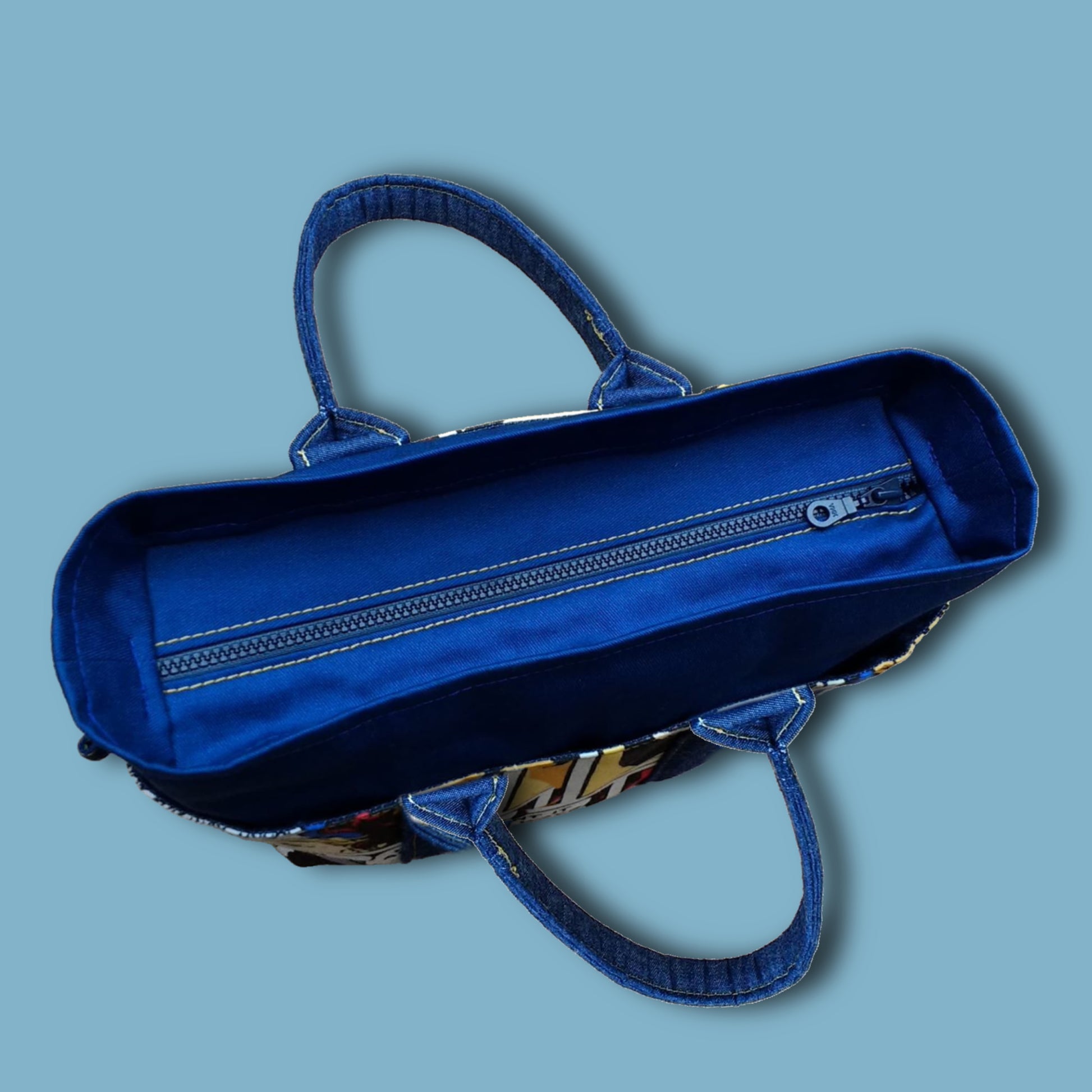 Mini tote bag in blue denim with Marvel contrast fabric for this kids bag pattern. Top view showing the recessed zipper.
