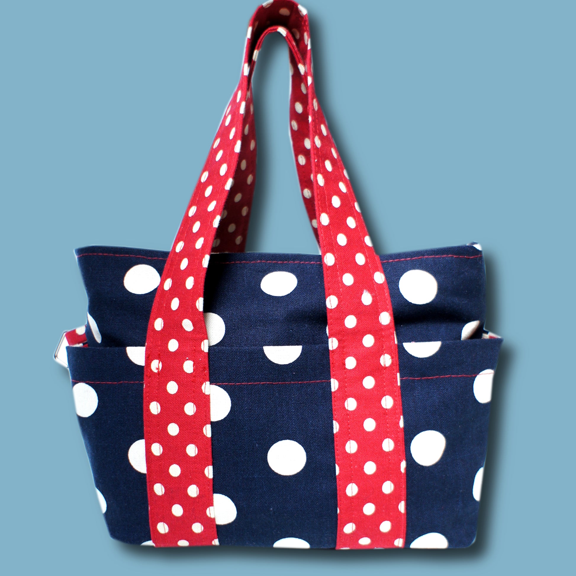Mini tote bag in heavy weight linen blue with white polka dots and small red and white polka dots for the handles. This pdf sewing pattern comes with a video guide.