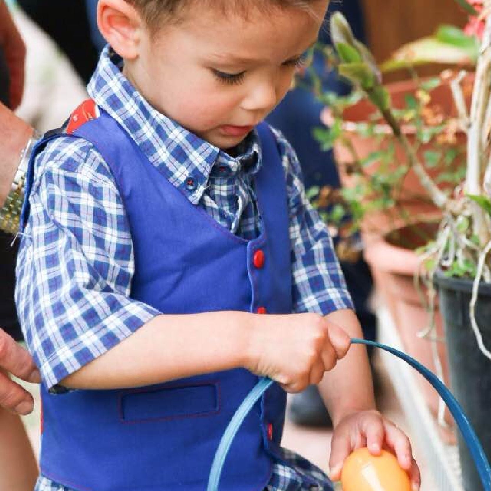 Brooklyn waistcoat, pdf sewing pattern by frocks and frolics. Fully lined with tie backs. Easter egg hunt, little boy wearing the waistcoat with red KamSnaps. Includes a free video sewing course.
