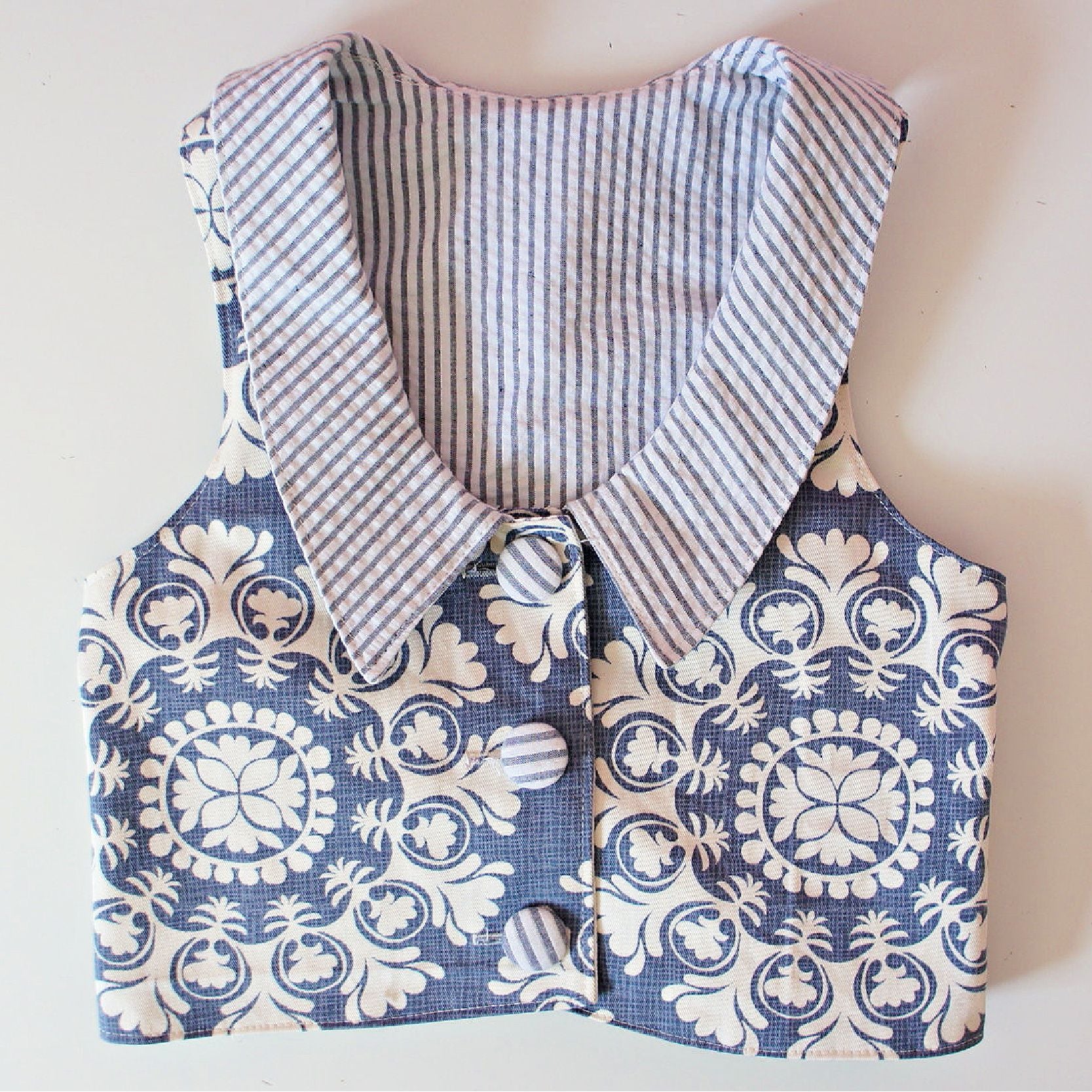 Brooklyn waistcoat, pdf sewing pattern by frocks and frolics. Fully lined with tie backs. Close up of front view for a girls boxy waistcoat. Includes a free video sewing course.
