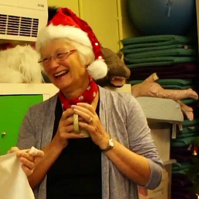 Two people in a room with a Christmas tree and decorations.