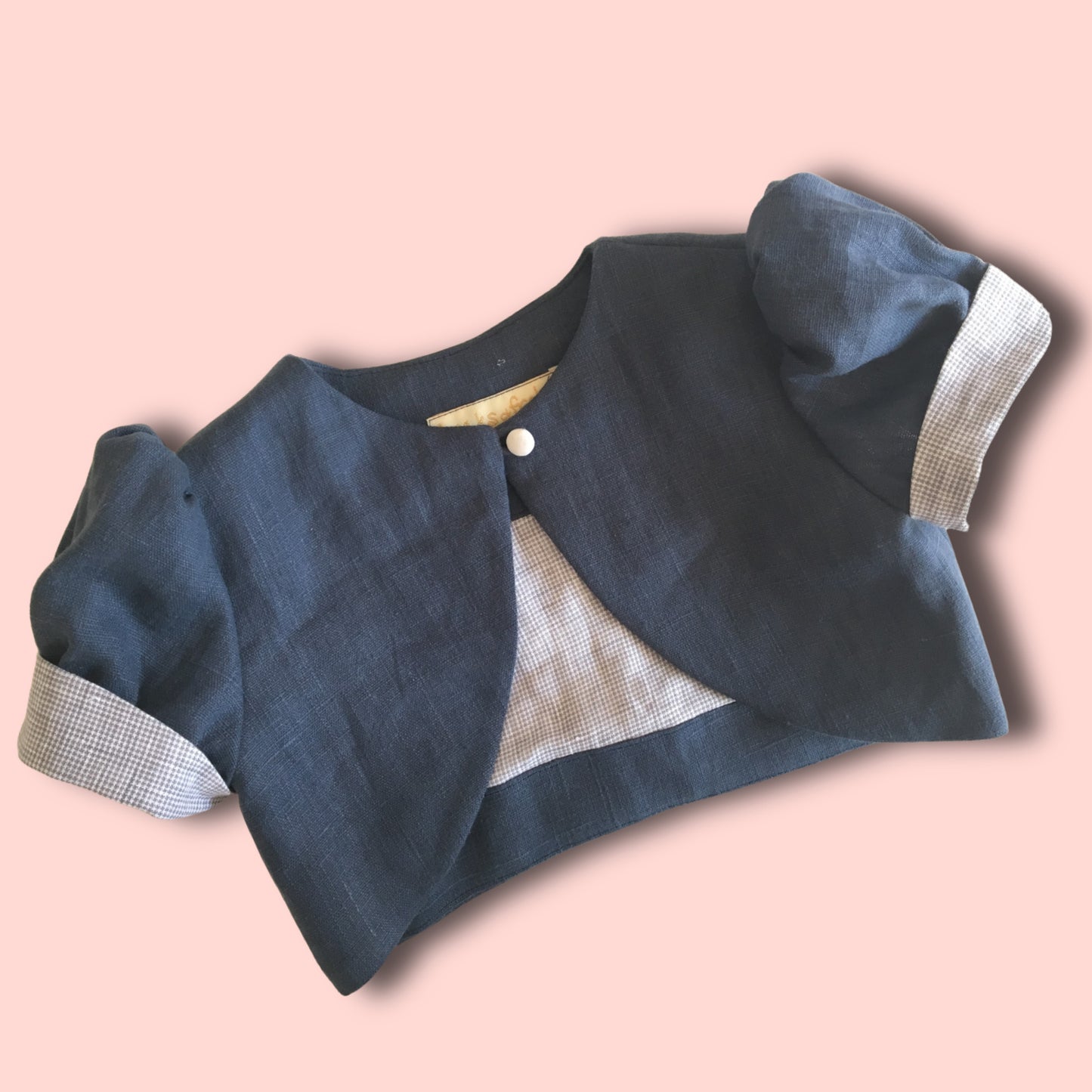 Bolero jacket, pdf sewing pattern by frocks and frolics. With puff sleeves or elasticated sleeves or pretty bias binding. Fully lined. In blue linen with Gingham lining and sleeve cuffs.