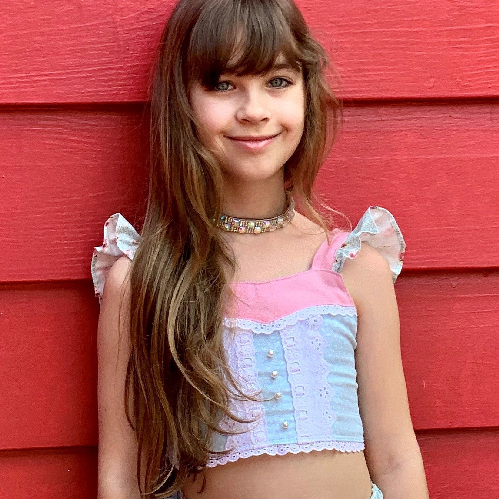 Connie blouse, pdf sewing pattern by Frocks & Frolics. Featuring a decorative yoke in pink linen with lace edging. Cute flutter sleeves in pastel blue and pink print by Michael Miller. Front bodice lace embroidery and pearl buttons complete the look.