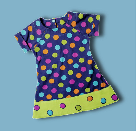 Daisy dress, pdf sewing pattern. Jersey dress with short raglan sleeves and faux turn up. The dress has a KamSnap back closure and deep decoratove hem trim. The pattern comes with a step-by-step video tutorial. Front view.