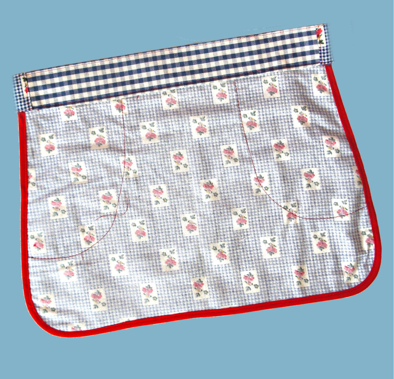 Christmas apron with snowman applique. Pdf sewing pattern by Frocks & Frolics. Fully lined, cute tie backs, free video sew-a-long. In gingham white and blue cotton with red trim bias binding and pockets.
