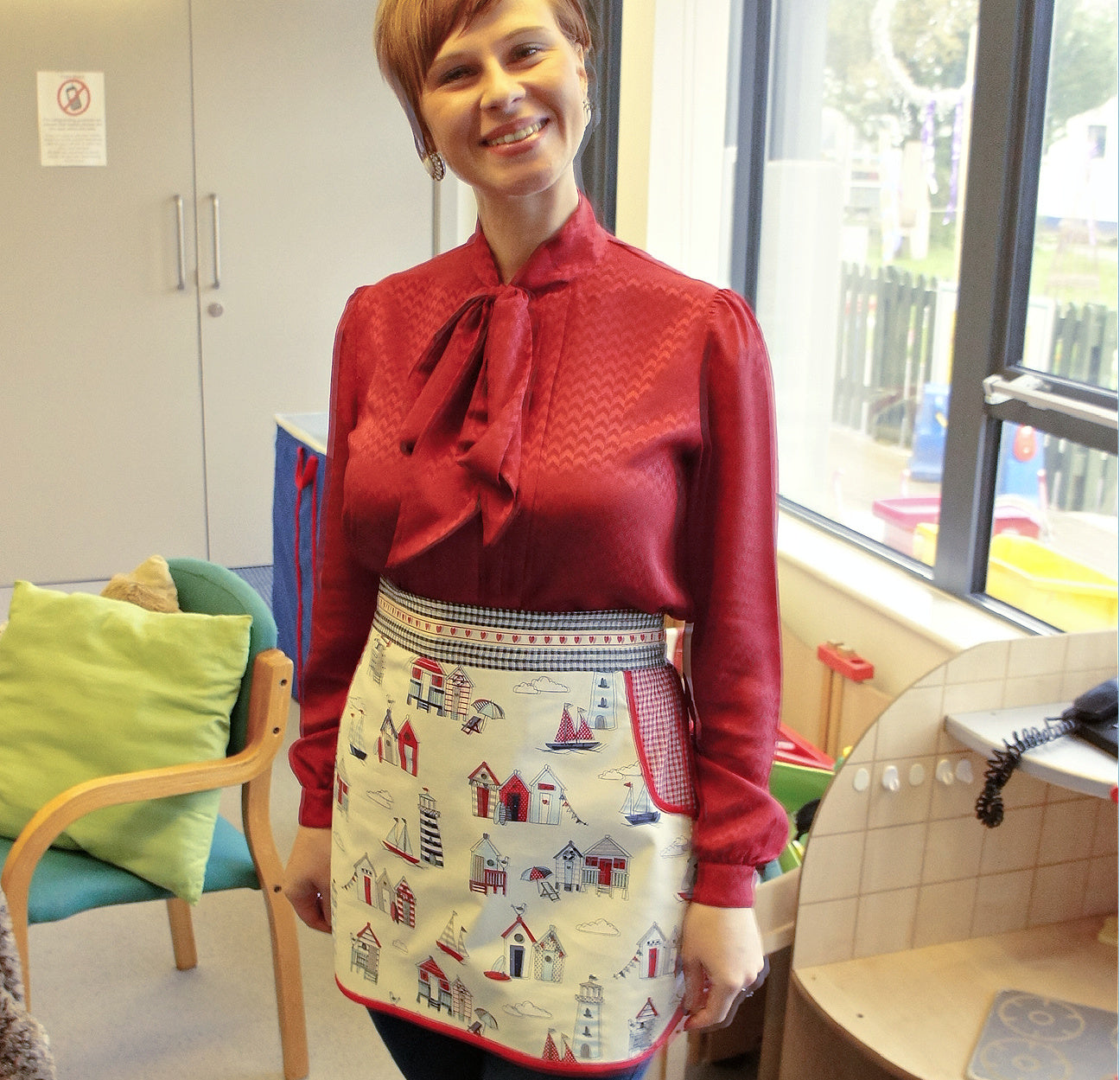 Christmas apron with snowman applique. Pdf sewing pattern by Frocks & Frolics. Fully lined, cute tie backs, free video sew-a-long. In gingham white and blue cotton with red trim bias binding and pockets.