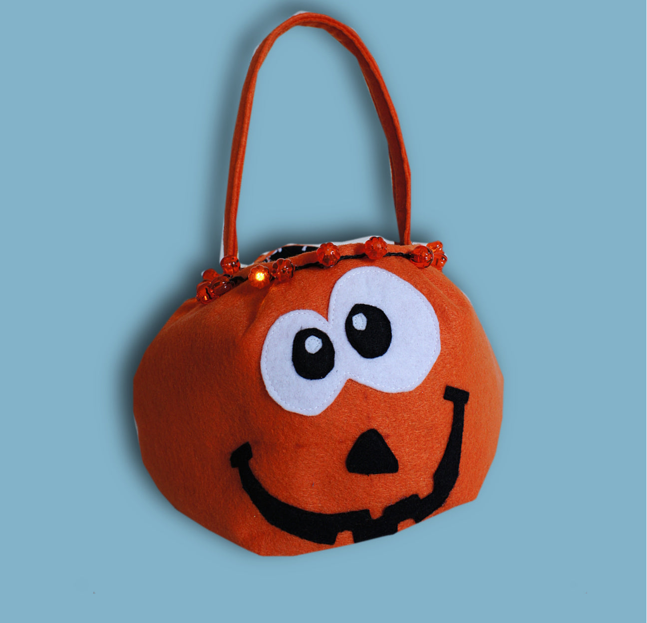 Halloween treat or trick basket, pdf sewing pattern by Frocks & Frolics. A pumpkin themed basket out of felt with blinking lights around the rim.