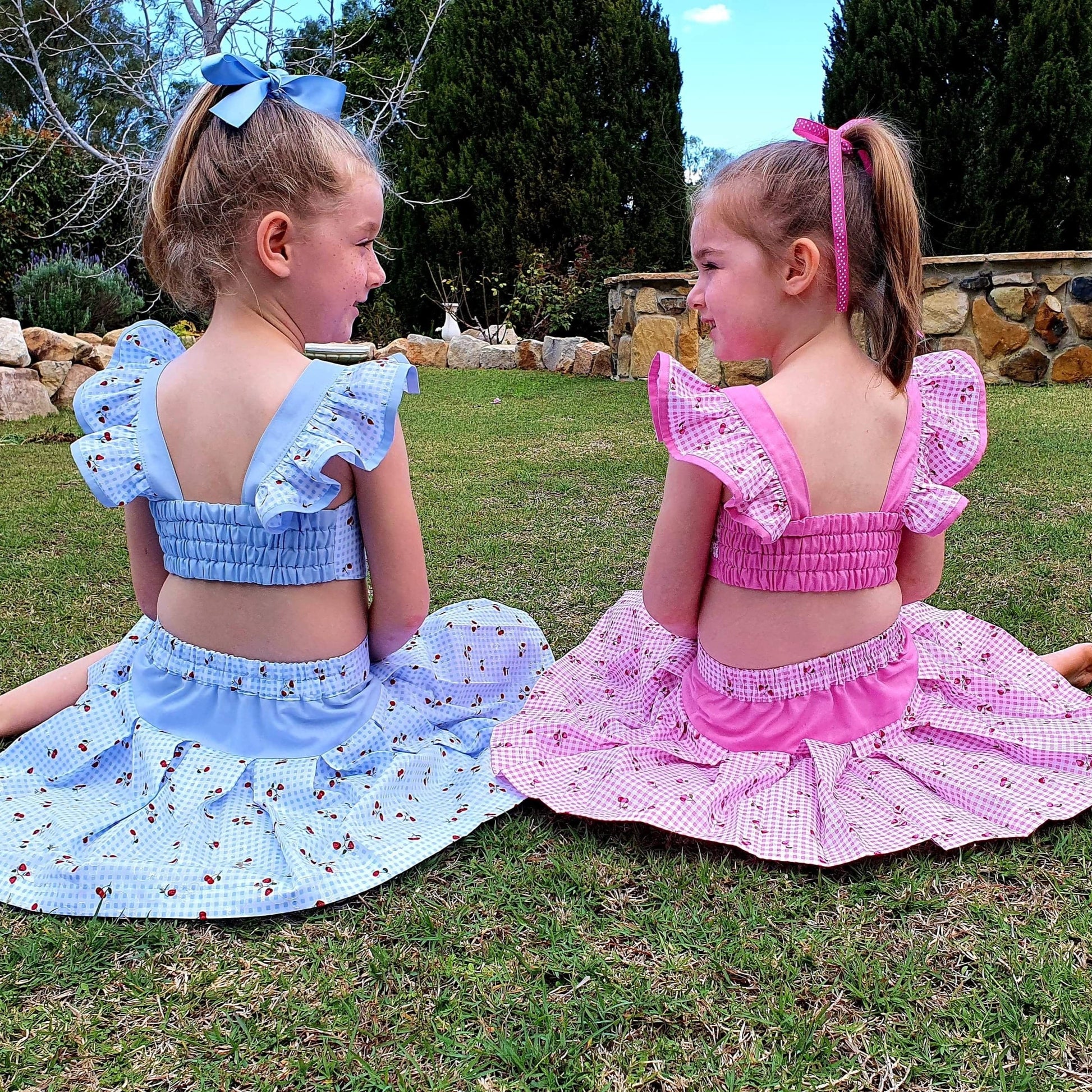Connie blouse, pdf sewing pattern by Frocks & Frolics. Featuring a decorative yoke in pink linen with lace edging. Cute flutter sleeves in pastel blue and pink print by Michael Miller. Front bodice lace embroidery and pearl buttons complete the look. Back view customer photo.