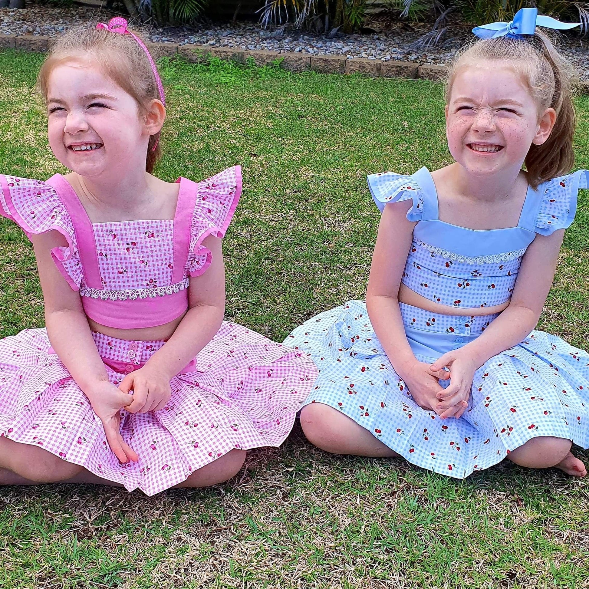 Connie blouse, pdf sewing pattern by Frocks & Frolics. Featuring a decorative yoke in pink linen with lace edging. Cute flutter sleeves in pastel blue and pink print by Michael Miller. Front bodice lace embroidery and pearl buttons complete the look.