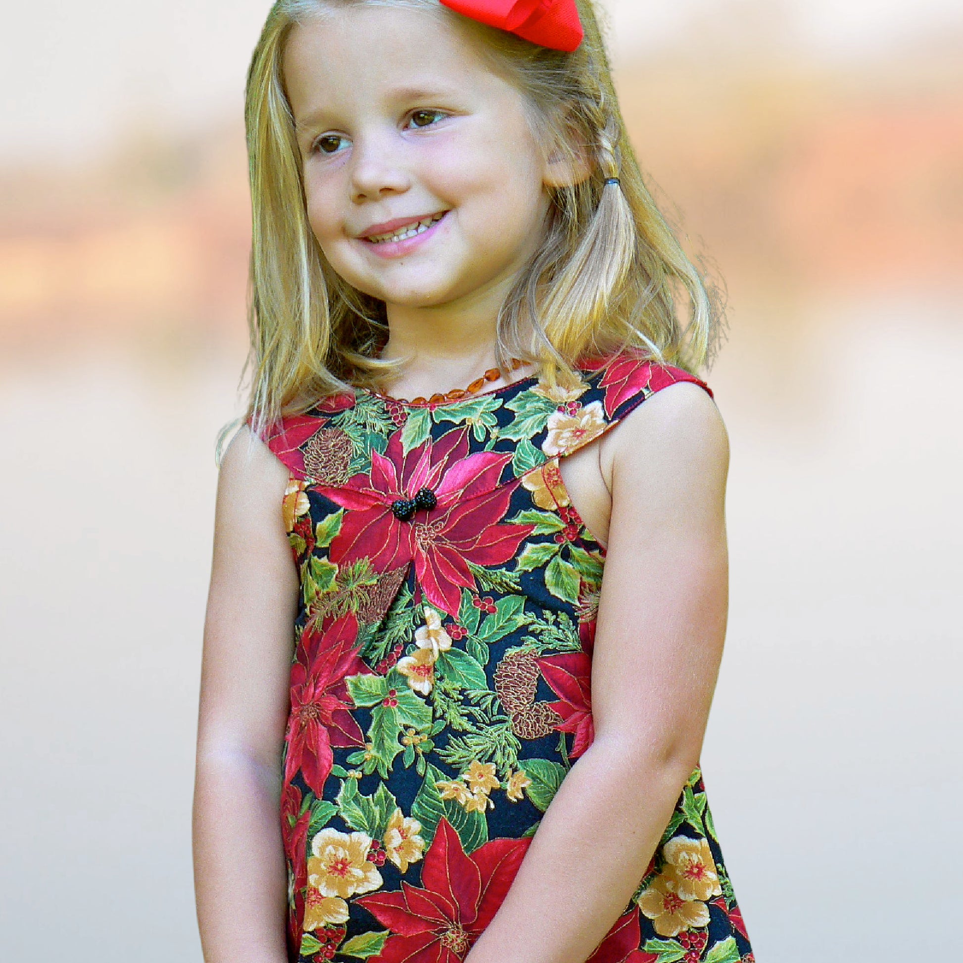 Pretty girl wearing a cute blouse with round yoke collar. Its in a Michael Miller Gingham and has decorative roses attached to the round yoke. The side view reveals a fully lined armhole. The hem has a slim lace trim.