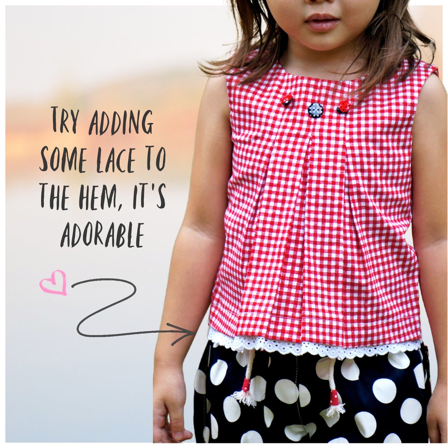 Lily girls dress, pdf sewing pattern by Frocks & Frolics. In red gingham with cute lace trim in white lace. Sleeveless with armhole and neckline facing. The pattern has video tutorials for all the sewing steps.