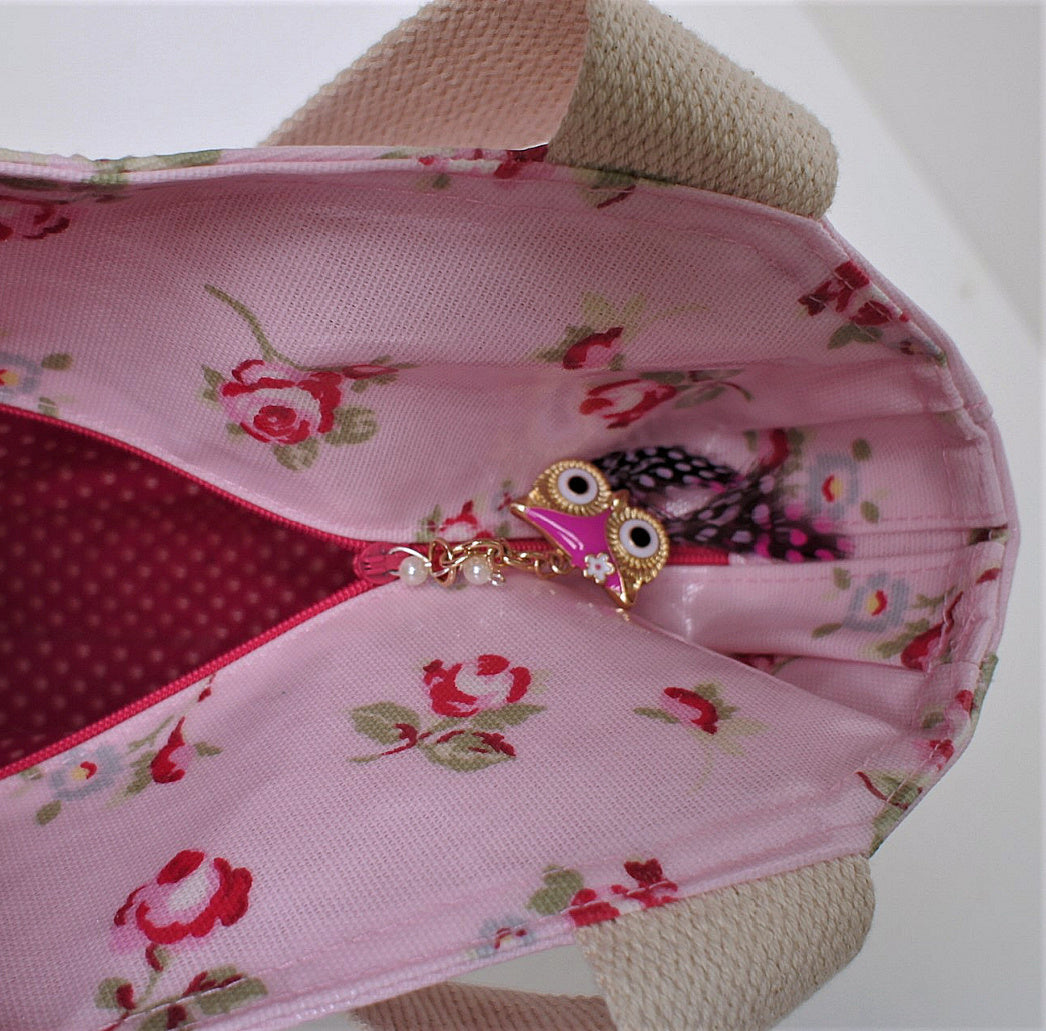 London tote bag pdf sewing pattern by Frocks & Frolics. In laminated oil cloth. Pink with dianty flowers. Wide handles and outside pockets. Fully lined, recessed zip. Comes with a free video course.