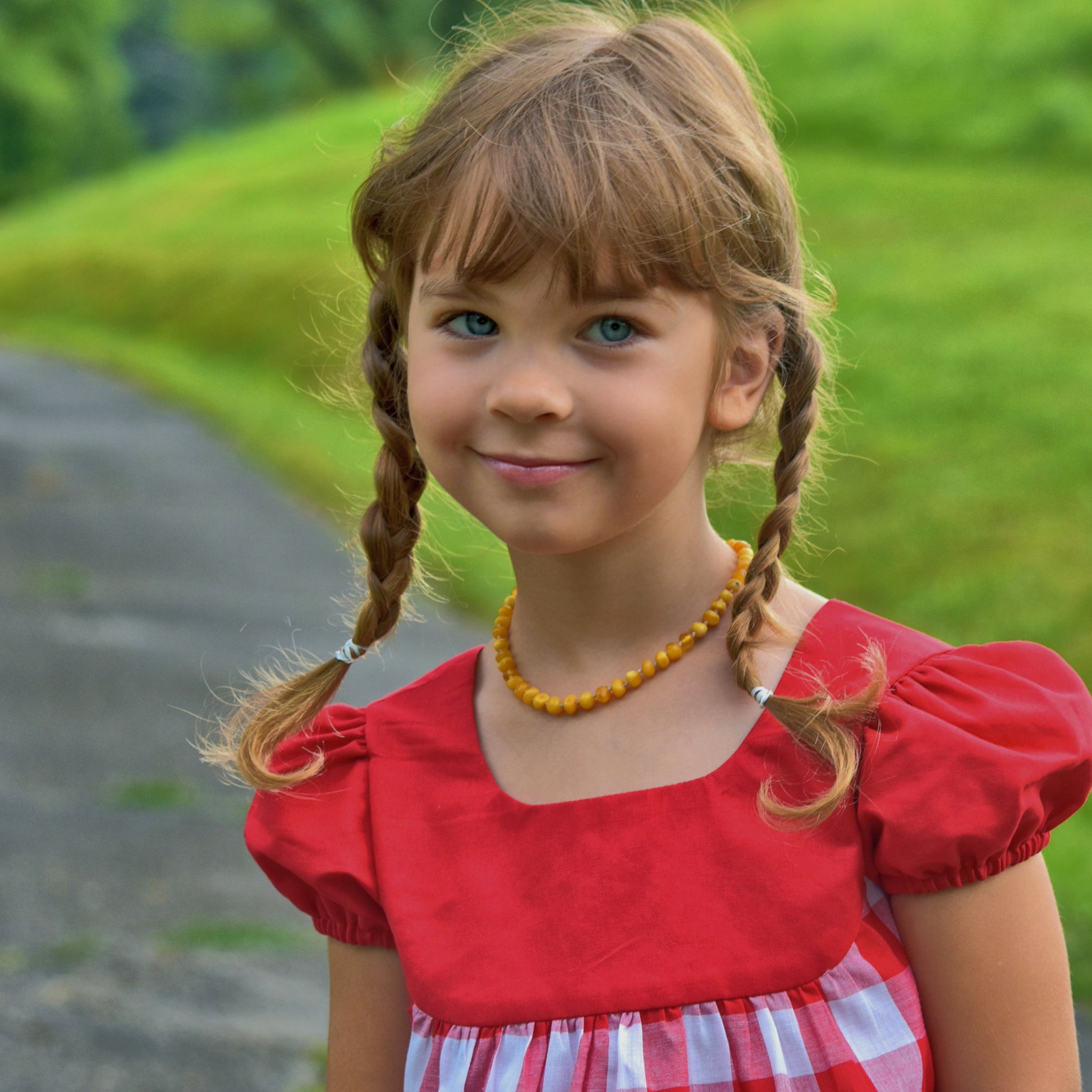 Millie dress pdf sewing pattern by Frocks & Frolics. Empire line bodice and slightly gathered skirt. Puff sleeves with elastication. Patch pockets with piping. Bodice has a cute lace trim. The fabric is white polka dots on a red cotton.