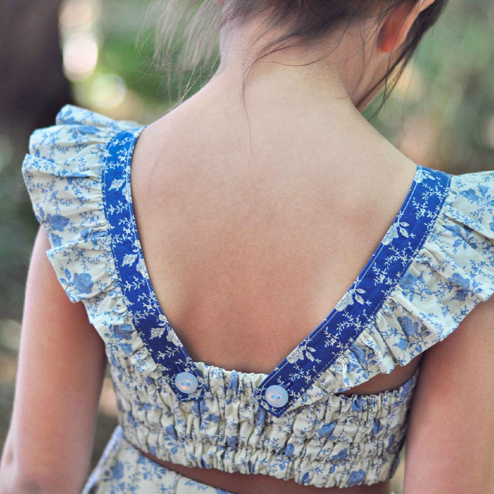 Tilly crop top, pdf sewing pattern by Frocks & Frolics. Cute girls blouse with flutter sleeves and vintage inspired. Back view showing the tunnels for the elastic and decorative buttons.