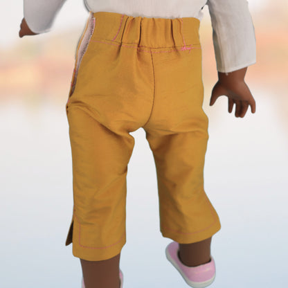 Audrey Capri pants, American girl pdf sewing pattern. Fits 18 inch dolls. Faux pockets, flat front waistband, elasticated in the back. Hem with slit made in mustard dupion silk. Comes with video tutorial. Back view.