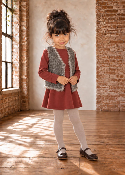Baby Vest sewing pattern – girl in grey shaggy faux fur vest over a red dress, front view