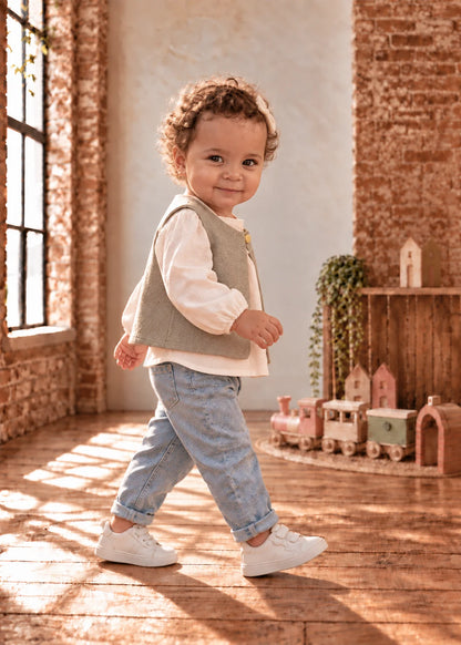 Baby Vest sewing pattern – toddler walking in sage shaggy reversible vest, side view