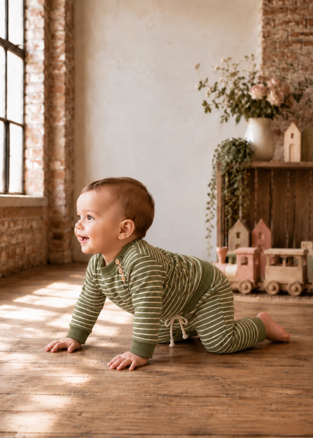 Bubble Gum Joggers sewing pattern – baby crawling in green striped joggers and top, side view