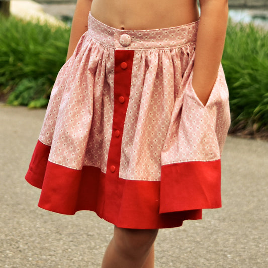 Betsy skirt, pdf sewing pattern by Frocks & Frolics. Skirt features a waistband with elastic in the back, a button down front and a deep hem trim. All version have step by step video tutorials completely free with the pattern.