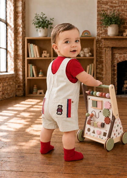 Bobby Dazzler Dungarees sewing pattern – baby in cream dungarees and red tee with a walker, back view