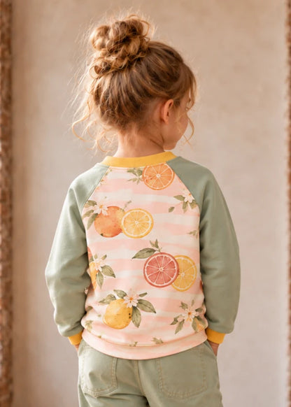Bubble Gum Joggers & Jelly Bean Sweater patterns – citrus print raglan sweater on a girl, back close-up