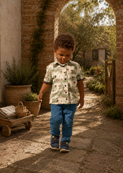 Back view of a toddler walking away in a bear and mountain print Cool Shirt with blue pants