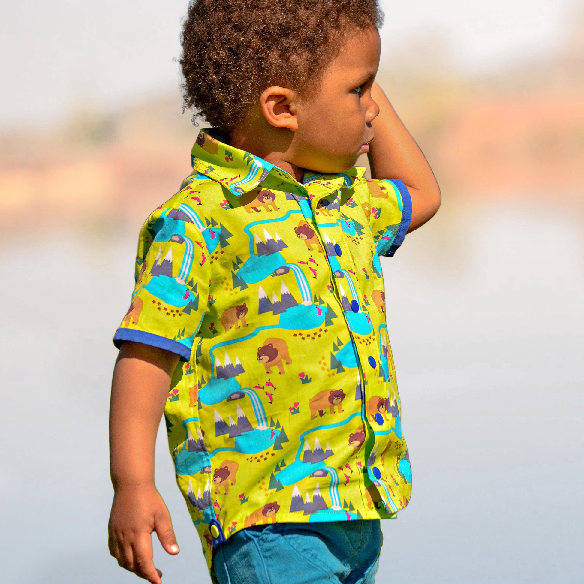 Cool shirt, pdf sewing pattern for a button down shirt by Frocks & Frolics.  The shirt has animal prints and a blue trim. High low hem feature. Includes a video sewing course explaining every step in detail. Front and side view.