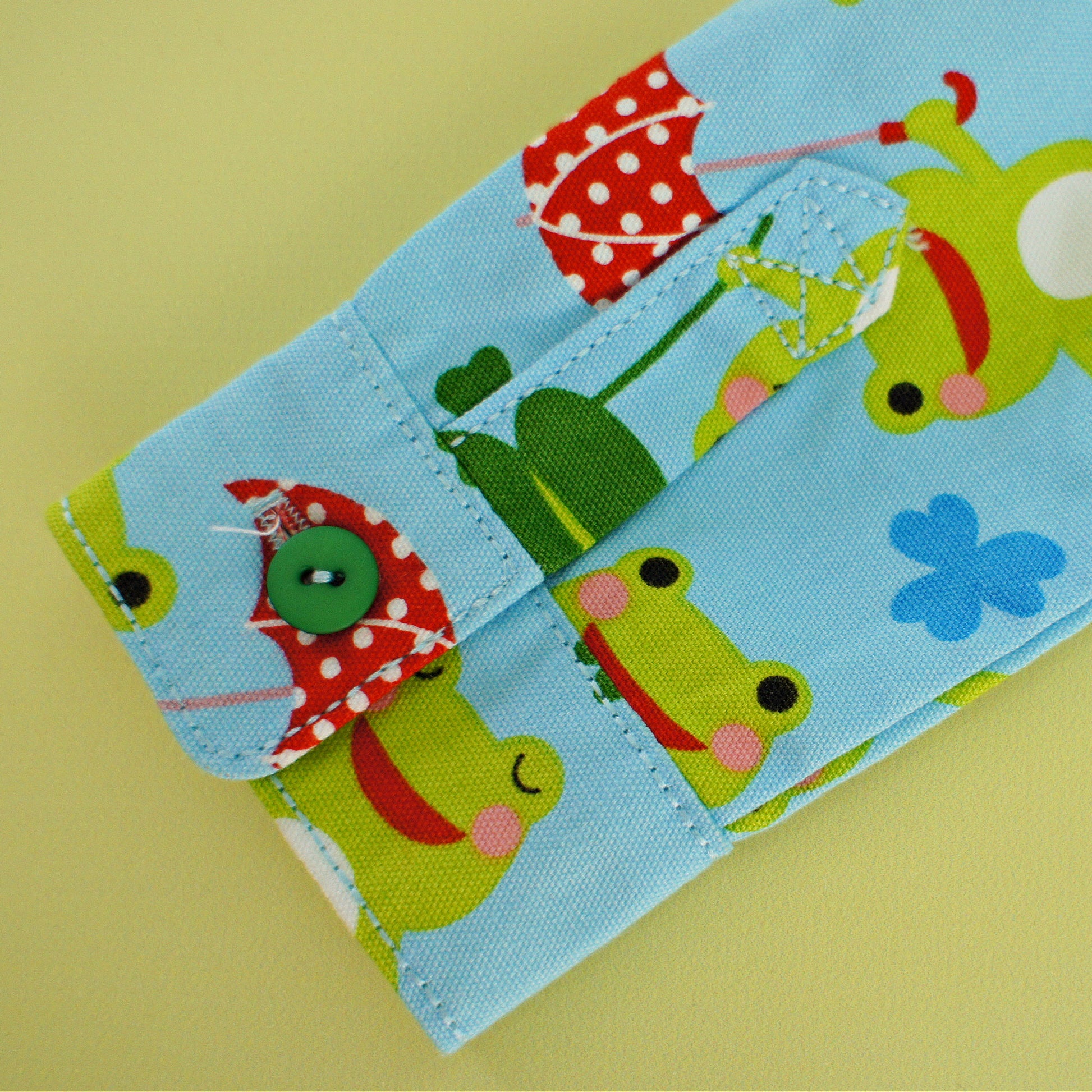 Cool shirt, pdf sewing pattern for a button down shirt by Frocks & Frolics.  The shirt has a cute frog print by Michael Miller fabrics. The pattern comes with a video guide for every step. Close up of the cuffs and placket.