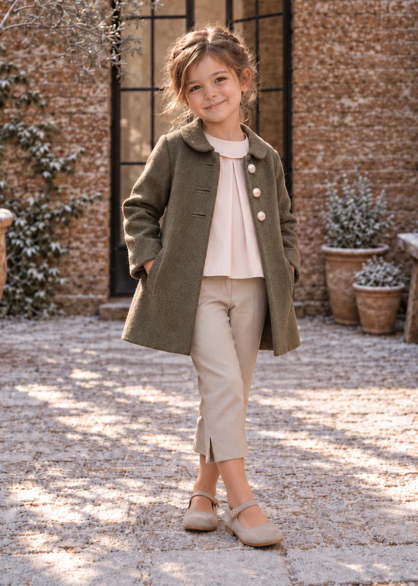 Dakota Pea Coat sewing pattern – smiling girl in short olive green coat over a pink top and cream trousers