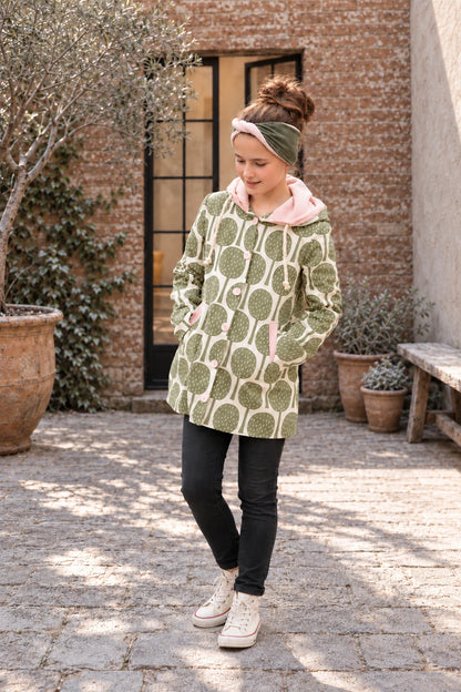 Dakota Pea Coat sewing pattern – sage leaf print jersey coat with pink hood, three-quarter view with black leggings