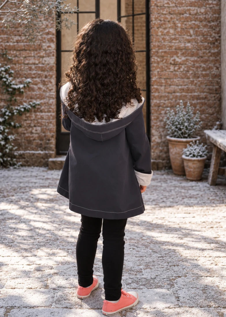 Dakota Pea Coat sewing pattern – back view of navy hooded coat with grey lined hood and black leggings