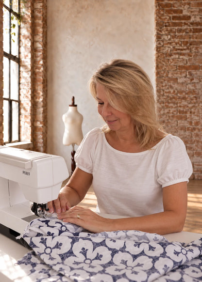 Devon Pants sewing pattern – pattern designer sewing a pair of printed pants at her sewing machine in the studio