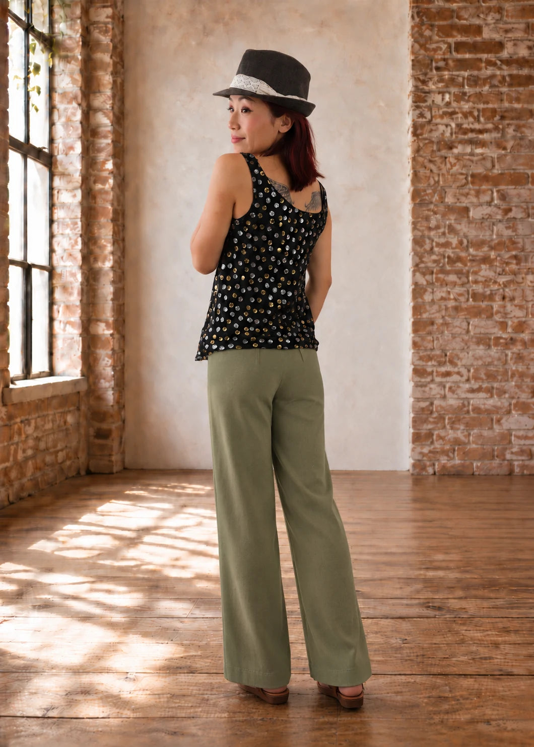 Devon Pants sewing pattern – back view of sage green straight-leg pants showing the back darts, with a black floral top