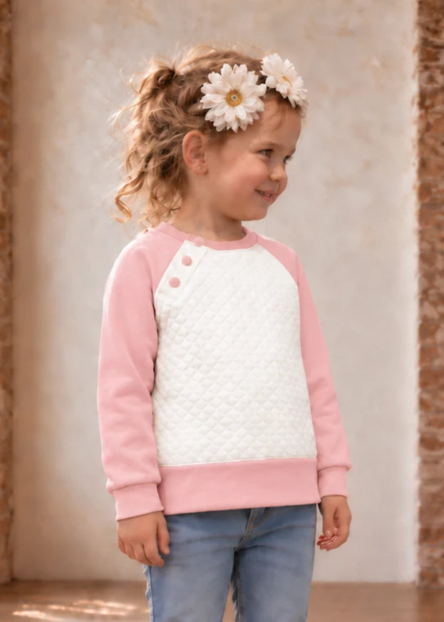 Jelly Bean Sweater sewing pattern – girl in pink and white quilted raglan sweater, side view