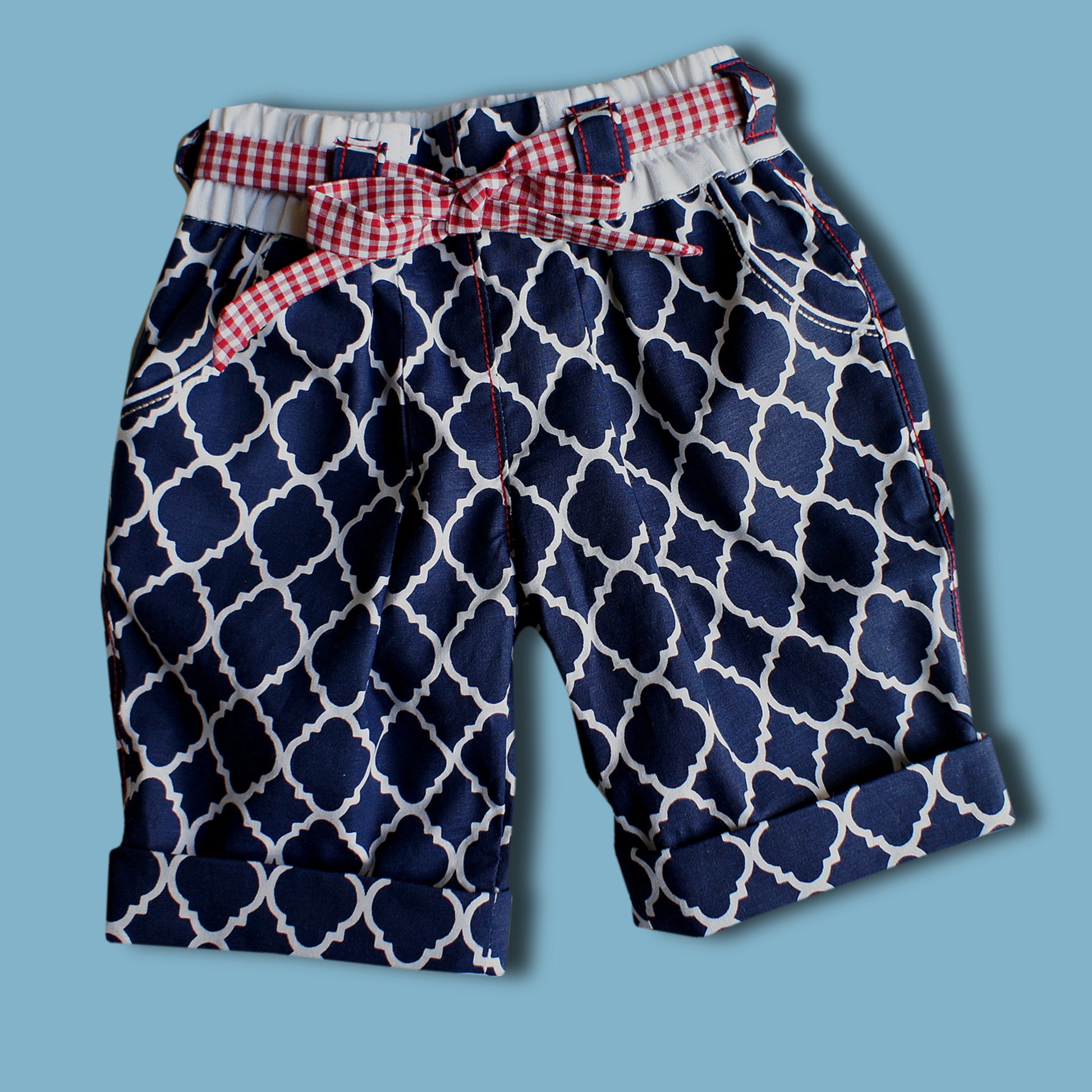 Maisy shorts pdf sewing pattern by Frocks & Frolics. Blue and white print with belt loopes, ties, side pockets and back patch pockets. The pattern includes video tutorials for every step.