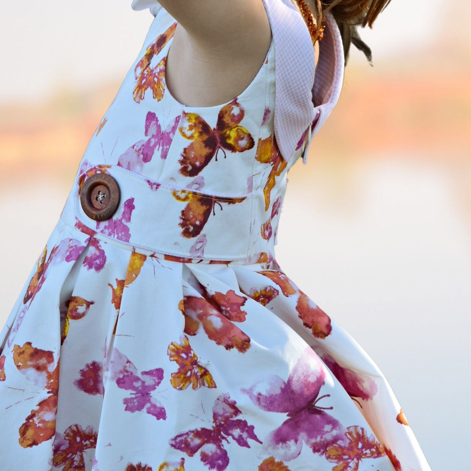 Vivienne dress for girls by Frocks & Frolics. Princess seam bodice, a sleeveless dress printed denim. Peter Pan collar with lower cut back. Pleated skirt. Large feature tabs with oversized button. Concealed zipper. 