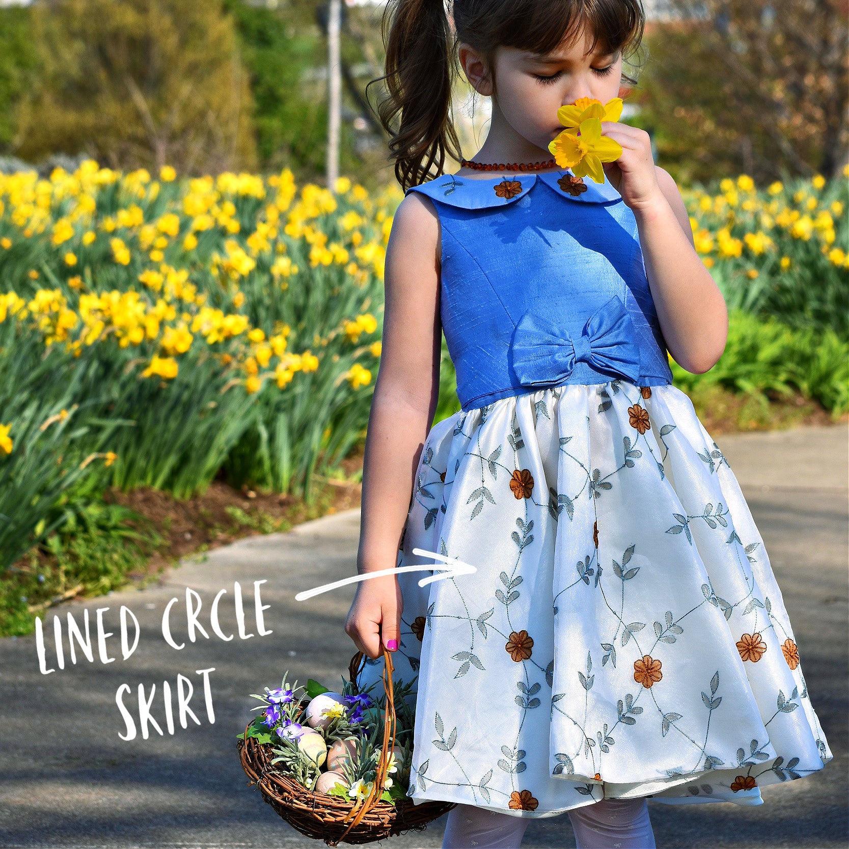 Vivienne dress for girls by Frocks & Frolics. Princess seam bodice, a sleeveless dress with dupion silk bodice and embroidered chiffon circle skirt. The silk Peter Pan collar is also covered in embroidered chiffon. Here the dress has a feature tie and front bow. Concealed zipper. 