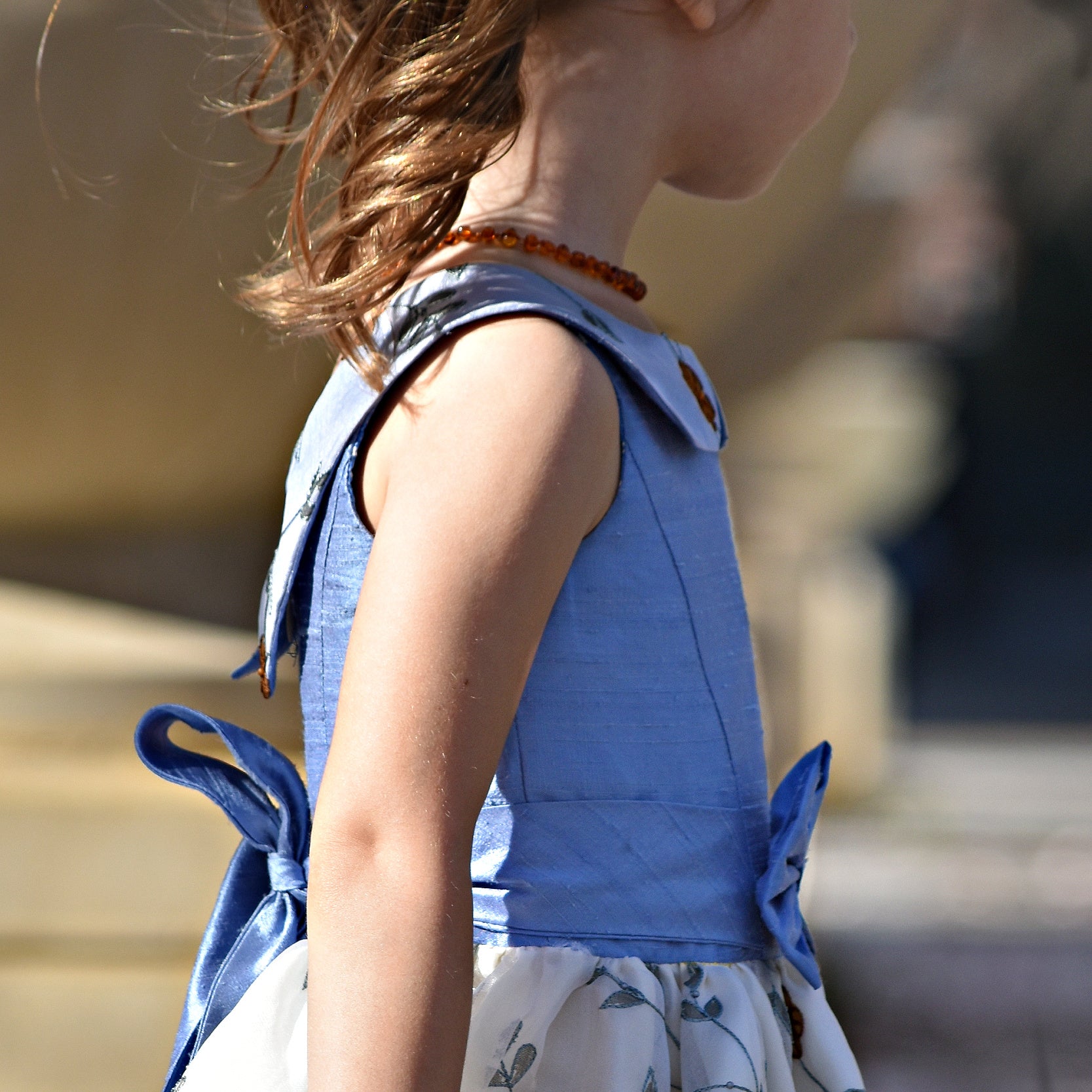 Vivienne dress for girls by Frocks & Frolics. Princess seam bodice, a sleeveless dress with dupion silk bodice and embroidered chiffon circle skirt. The silk Peter Pan collar is also covered in embroidered chiffon. Here the dress has a feature tie and front bow. Concealed zipper. 