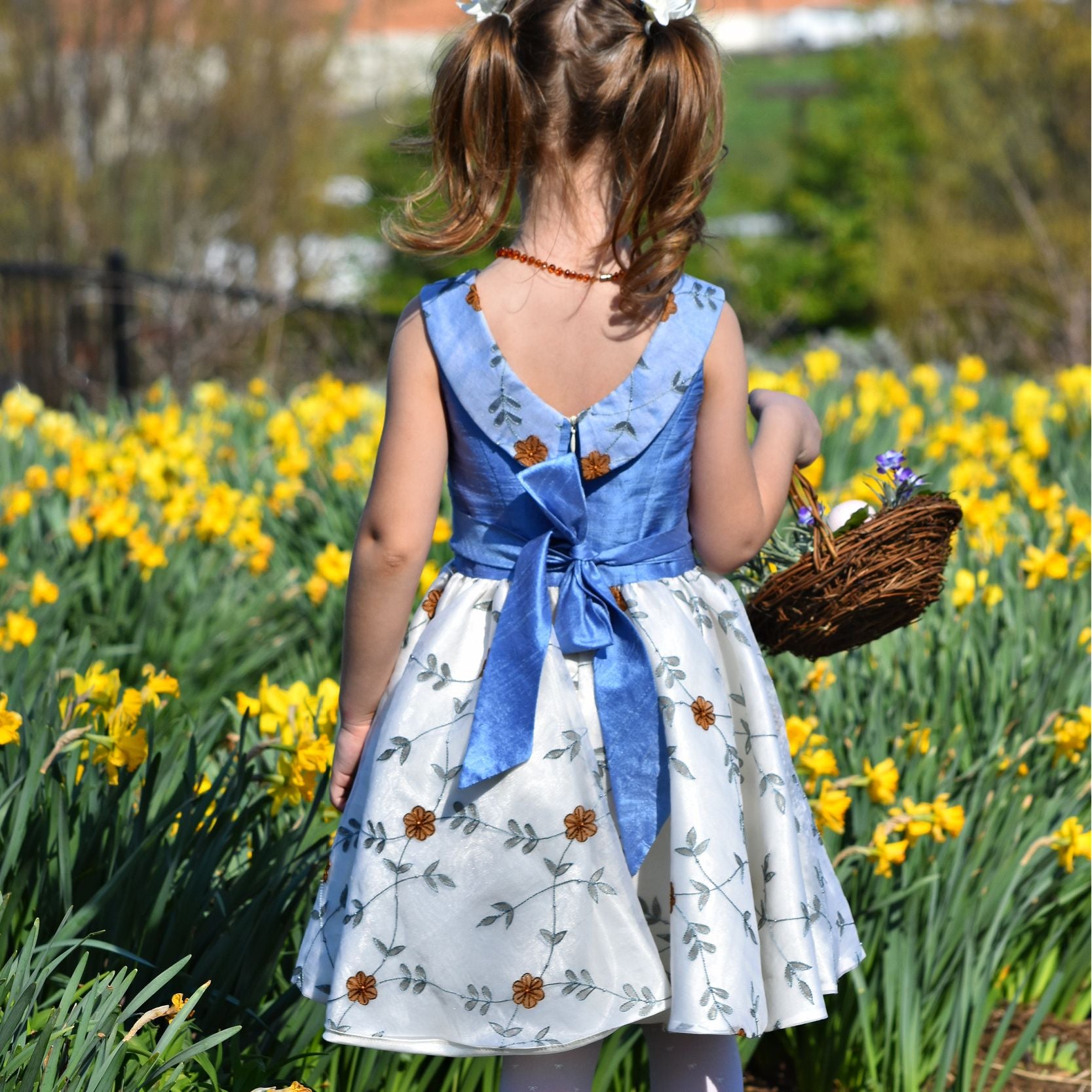 Vivienne dress for girls by Frocks & Frolics. Princess seam bodice, a sleeveless dress with dupion silk bodice and embroidered chiffon circle skirt. The silk Peter Pan collar is also covered in embroidered chiffon. Here the dress has a feature tie and front bow. Concealed zipper. 