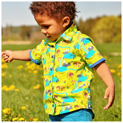 Cool shirt, pdf sewing pattern for a button down shirt by Frocks & Frolics.  The shirt has animal prints and a blue trim. High low hem feature. Includes a video sewing course explaining every step in detail. Side view featuring the high low hemline.