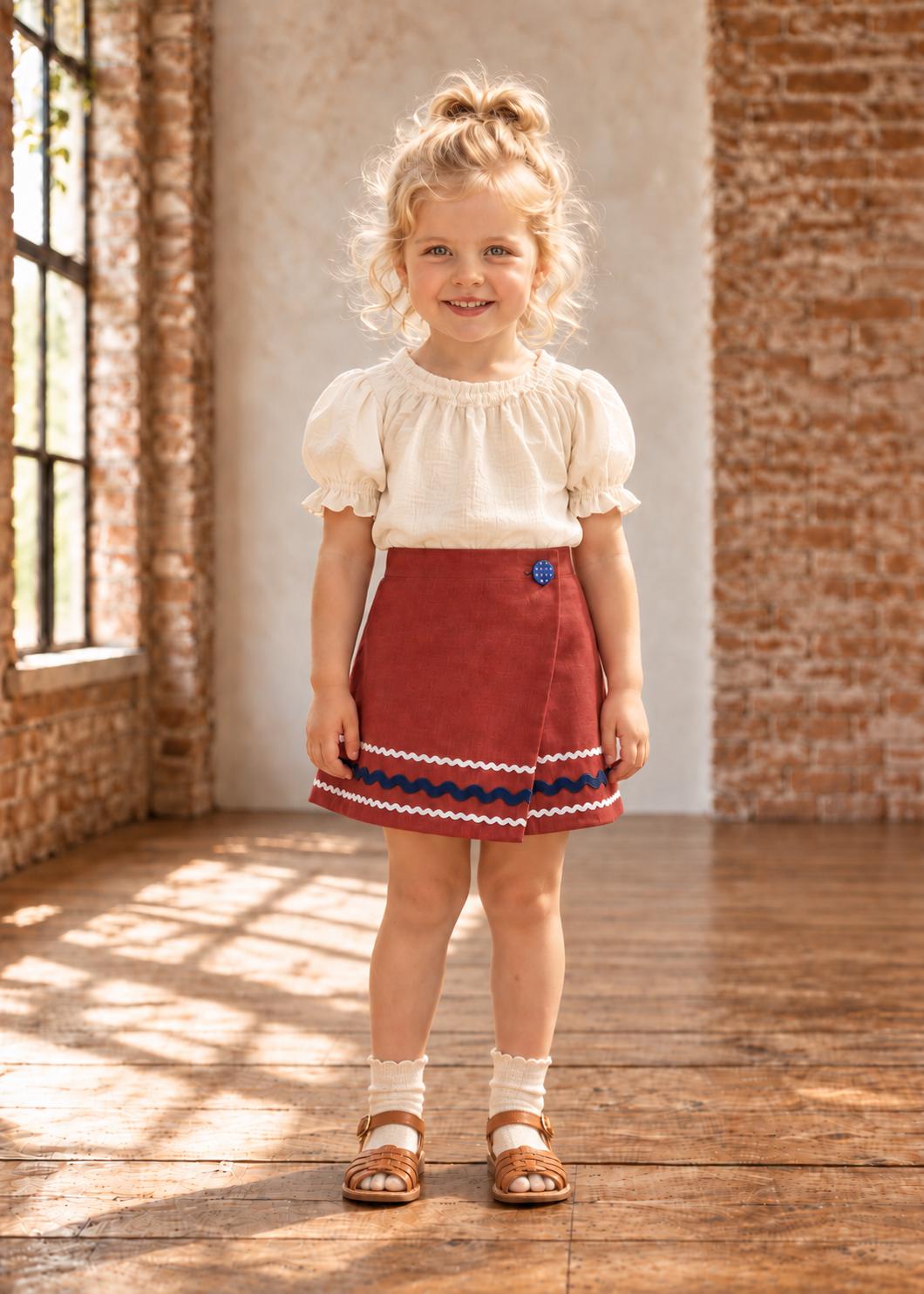 Frocks & Frolics Jutta wrap skirt sewing pattern – rust wrap skirt with navy wave trim and blue button