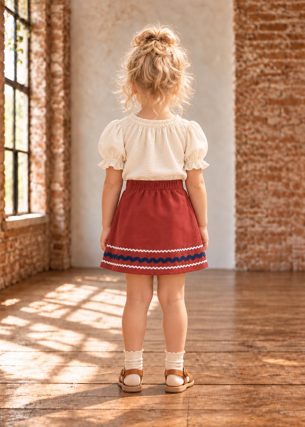 Frocks & Frolics Jutta skirt sewing pattern – back view of rust skirt with navy and white wave trim