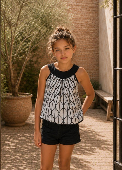 Frocks & Frolics Kitty top sewing pattern – sleeveless black and white print top with black round yoke, worn with shorts