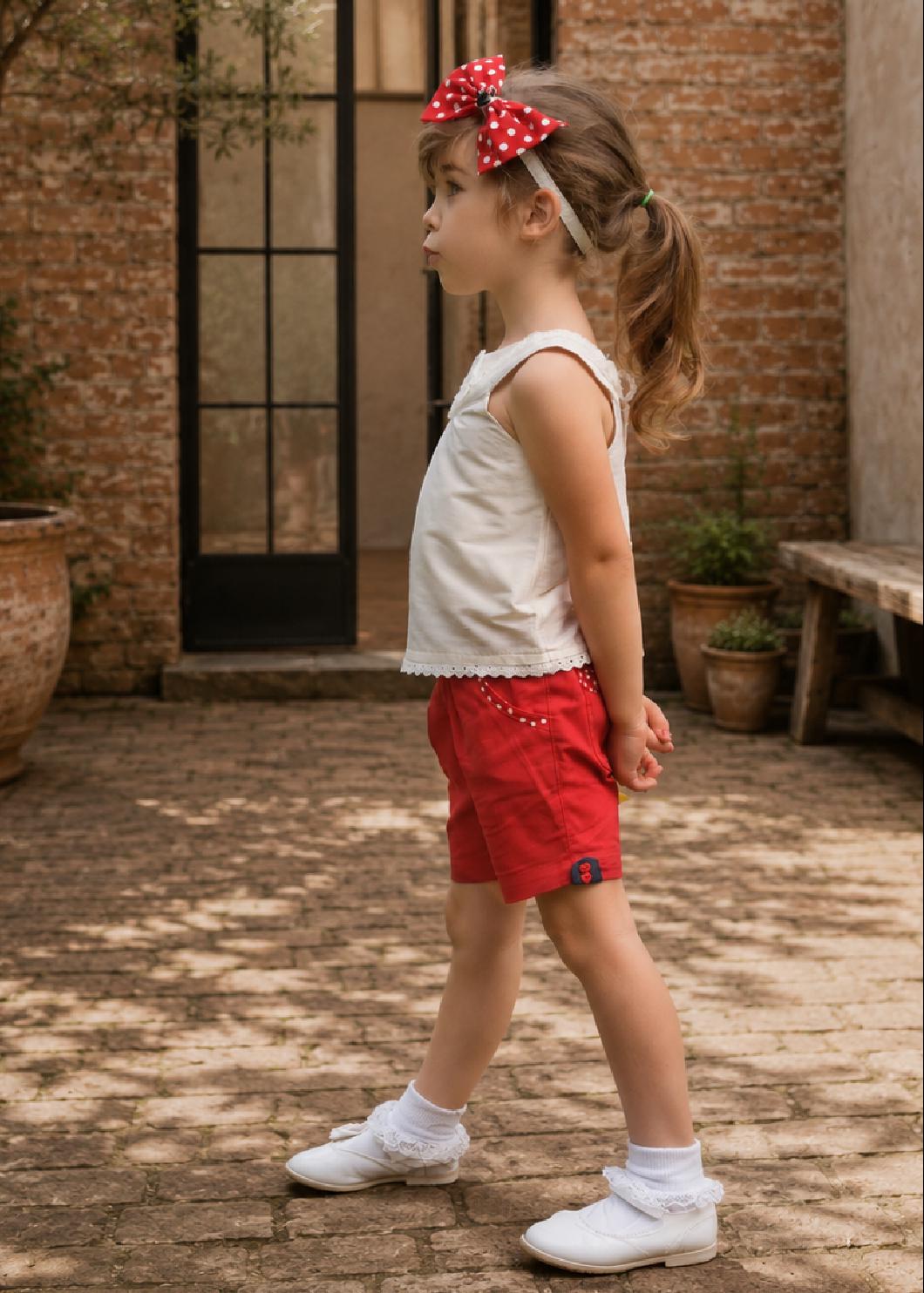 Frocks & Frolics Maisy shorts sewing pattern – side view of red shorts with white polka dot pocket accents