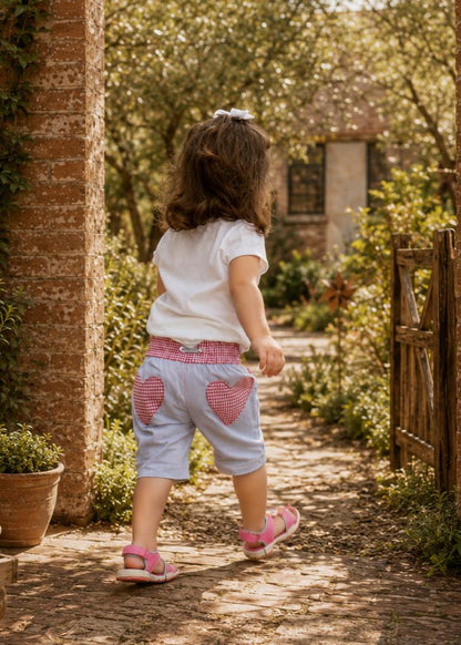 Frocks & Frolics Maisy shorts sewing pattern – back view of light blue shorts with gingham heart pockets