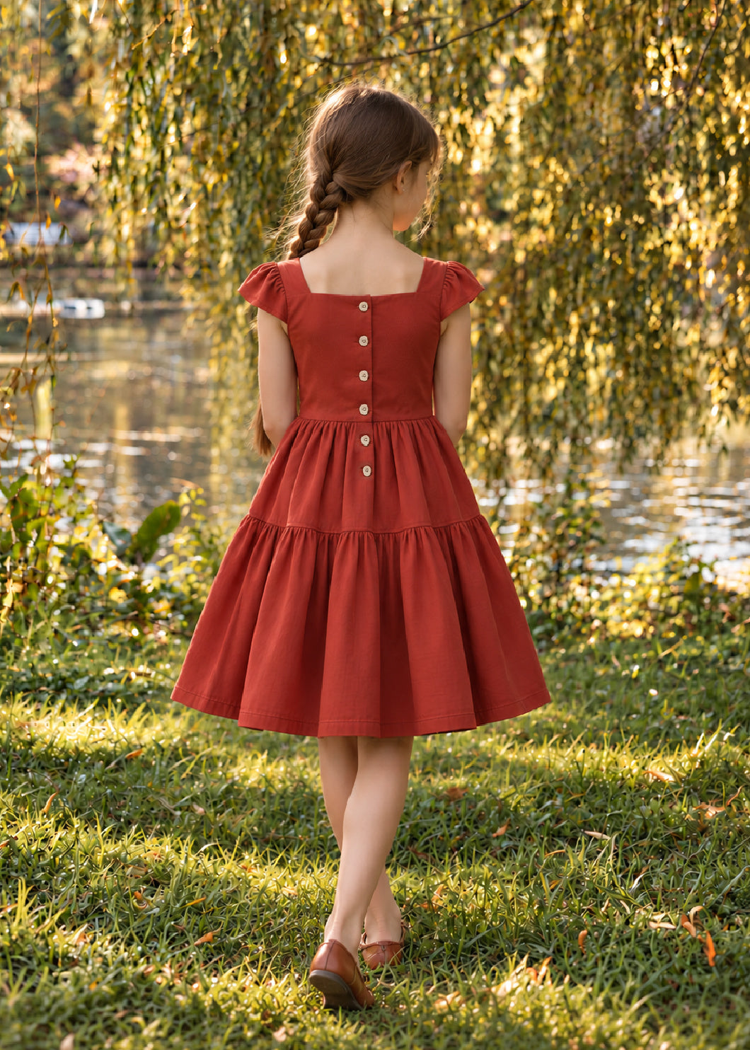 Isabella Dress PDF sewing pattern. Back view of a girl in a red tiered dress showing the button-down back closure and cap sleeves.