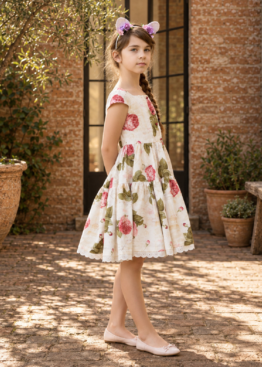 Isabella Dress PDF sewing pattern. Girl with flower ears headband wearing a white rose print vintage dress with cap sleeves and a full tiered skirt.