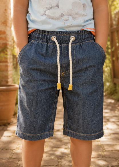 Close-up front view of the Oscar Shorts denim waistband showing the elastic casing, metal eyelets, and cotton rope drawstring with wooden cord ends