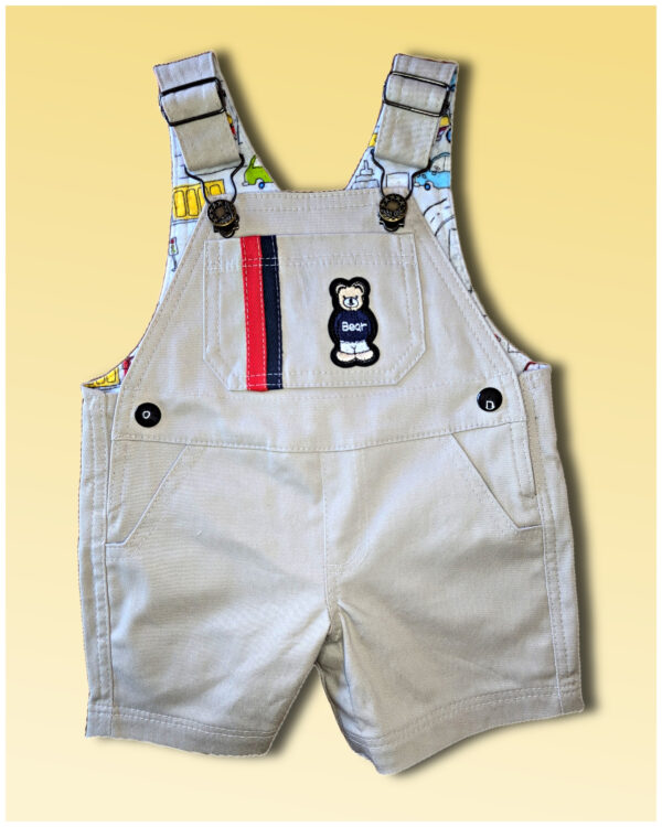 Short dungarees for the summer. Front view patch pockets with Teddybear application and stripes in red and blue. Bobby Dazzler dungarees sewing pattern.